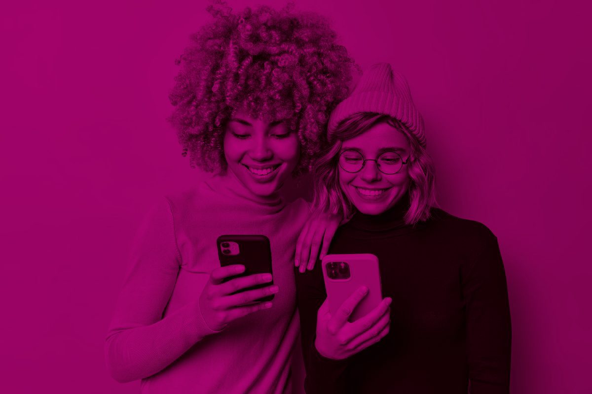 Two women looking at their phones, duotone magenta photo